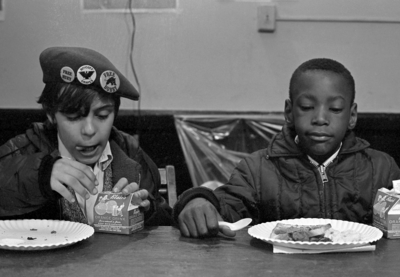 Two kids eating breakfast together.