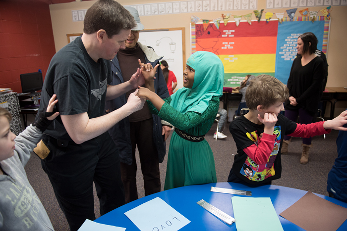 John Lee Clark uses tactile communication with a student