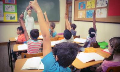 Students raising their hands in class