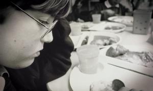 Photo of a student sad, staring at his food plate