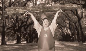 Olympic bronze medalist weightlifter Cheryl Haworth holding a log over her head