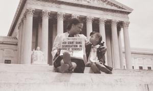 Mother and daughter hold Newspaper with headline "High Court Bans Segregation In Public Schools"