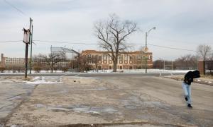 Student running on the desert snowed roads in front a public school in Chicago