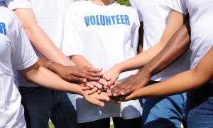 Volunteers put their hands together in solidarity.