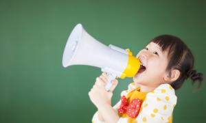 A small girl yells into a megaphone