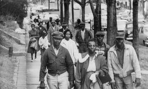 Organizers march down a street