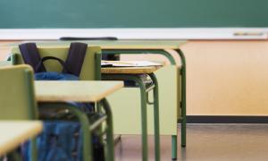 desk with backpack in empty classroom