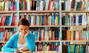 female student reading in library