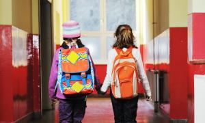 girls holding hands walking down hall