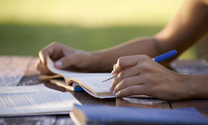 hands writing in workbook