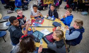 Students sit around a table talking