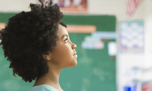 Girl, pictured from a side profile, looking up to focal point off camera