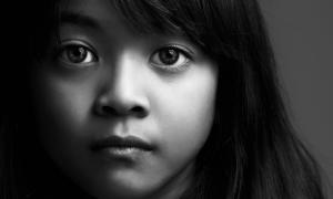 sad girl gazing at camera in black and white
