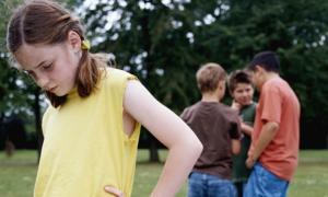 huddle of boys with girl in foreground feeling left out