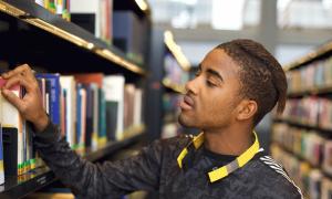 male teenager browsing at library