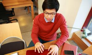 male student working at computer in libary