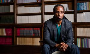 Dr. Ibram Kendi sitting in front of a book shelf