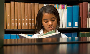 Student reading at library table