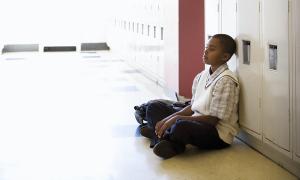 Young African-American Child Sitting Against Locker