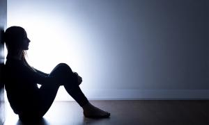 Sitting student silhouetted against light