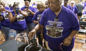 Woman on Charlottesville to Montgomery pilgrimage transfers soil from one jar to another