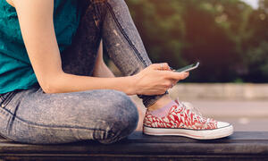 Person wearing red sneakers checking their phone