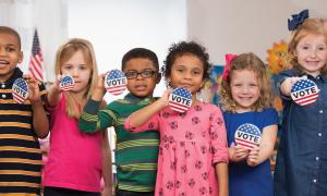 Young kids holding Vote buttons