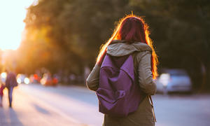 Student with long hair and purple book bag on.