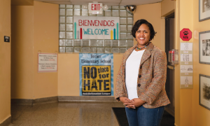 Angela Ward standing in a hallway with a variety of posters on the walls.