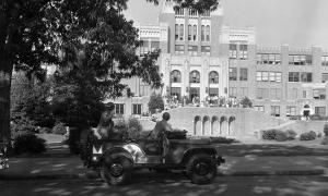 Members of the Arkansas National Guard looking on as students gather outside of the entrance of Little Rock High School.