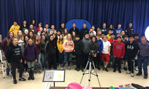 Large group of students gathered together in auditorium for a group photograph.