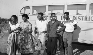 Black students in Mansfield, TX during integration crisis, standing in front of a school bus