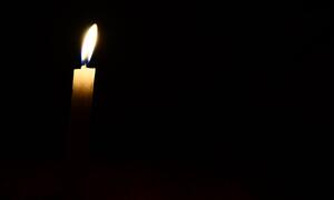 A single lit candle surrounded by darkness.