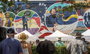 A mural commemorating Juneteenth stretches across the wall of a building. 