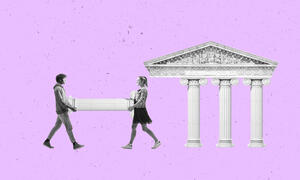 Two people carrying a column to a building