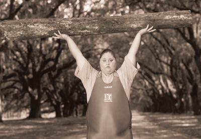 Olympic bronze medalist weightlifter Cheryl Haworth holding a log over her head