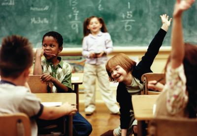 Classroom photo with students raising hands