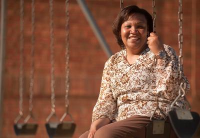 A woman sits on a swingset