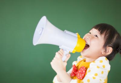 A small girl yells into a megaphone