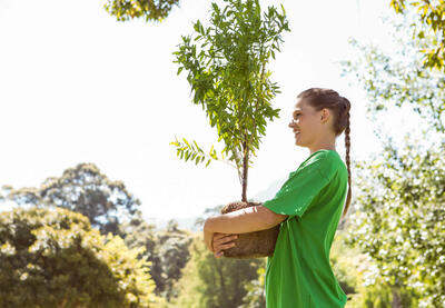 A young person plants a tree.