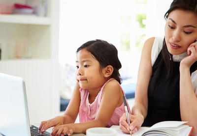 asian mother talking on phone with daughter on computer