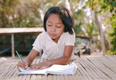 A girl writes in her notebook.