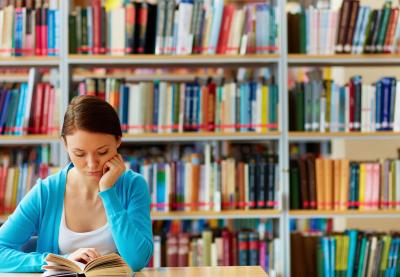 female student reading in library