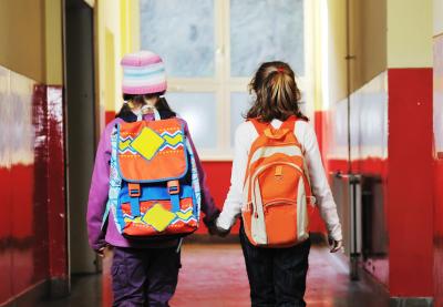 girls holding hands walking down hall