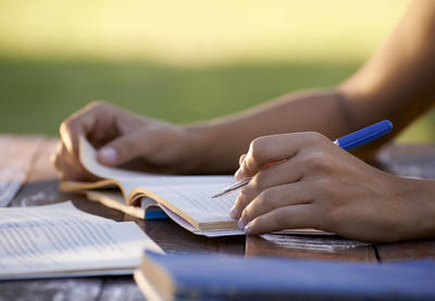 hands writing in workbook