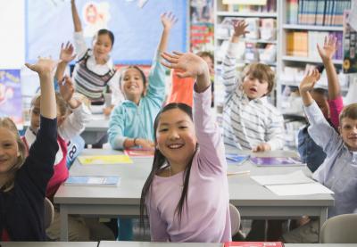 students raising hands in class