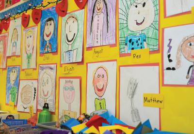 Children's self-portraits hanging on a wall