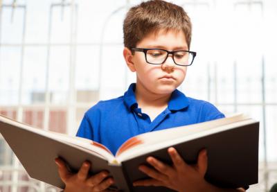 Boy in glasses reading a book