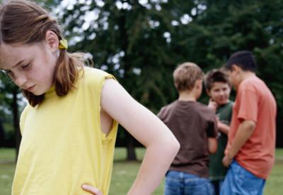 huddle of boys with girl in foreground feeling left out