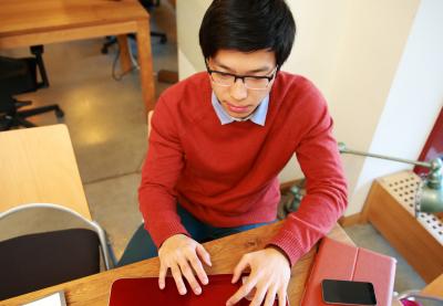 male student working at computer in libary